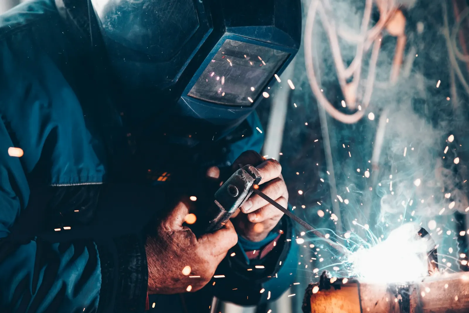Welder in a protective mask working with sparks flying